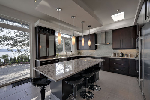 Bianco Antico Granite with Espresso Stained Cross Reeded Glass Cabinet Doors, Porcelain Flooring, Skylight Window and Glass Mosaic Backsplash